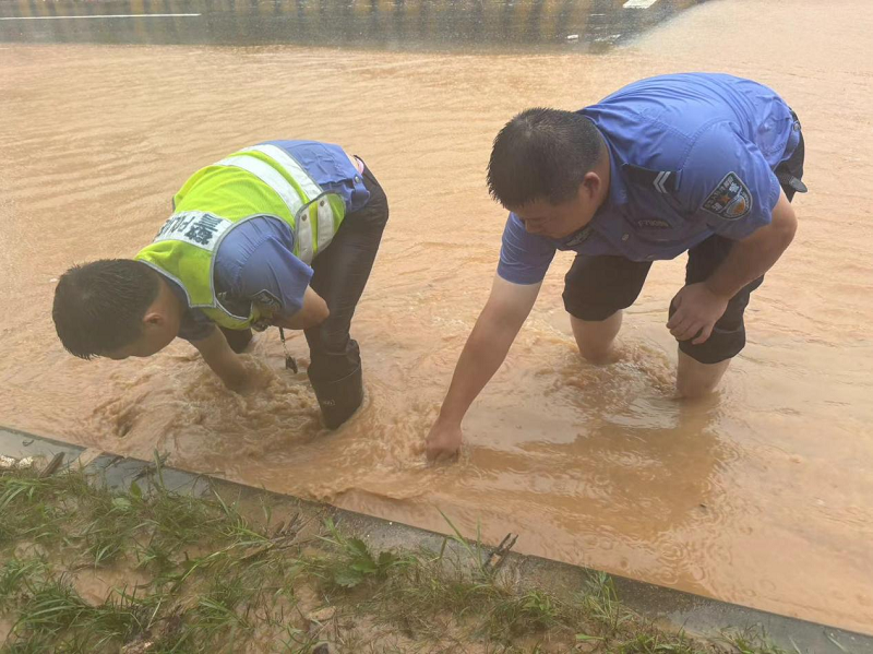 防汛進行時丨全力保暢通！湘陰交警徒手疏通排水口